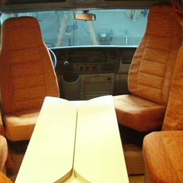 Dinette con sedute tessuto arancione coordinate ai sedili orientabili della cabina di guida.
